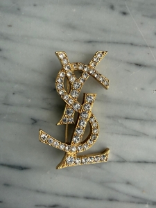 Yves Saint Laurent broszka w kolorze złotym ze srebrnymi kryształkami. 